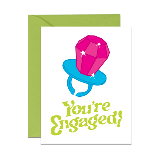 greeting card with sparkly ring pop read you're engaged in bright green text