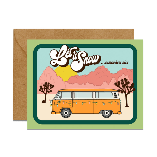 joshua tree desert rocks background, Volkswagon bus with christmas tree lights. Graphic reads "Let it snow...somewhere else"